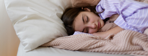 Close-up of teenage girl sleeping in the bed.