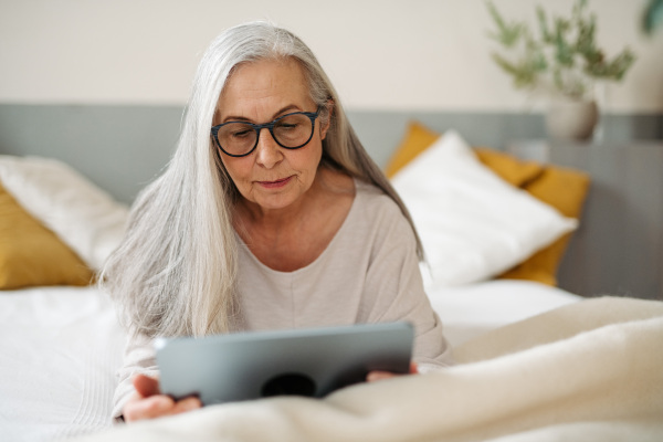 Senior woman spending her free time with a digital tablet.