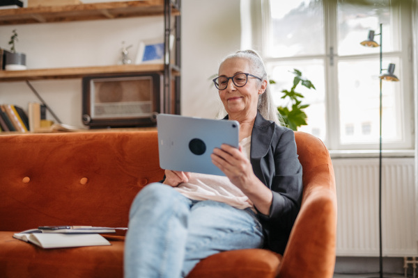 Senior woman spending her free time with a digital tablet.