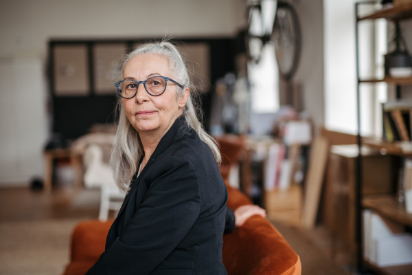 Portrait of pensive senior woman sitting in her home.