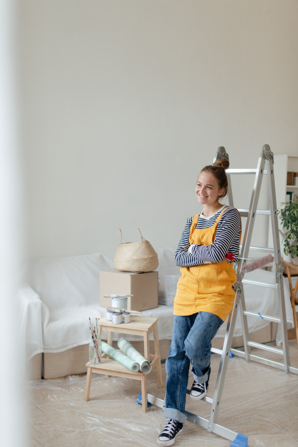 Happy young woman having break during renovation her house.