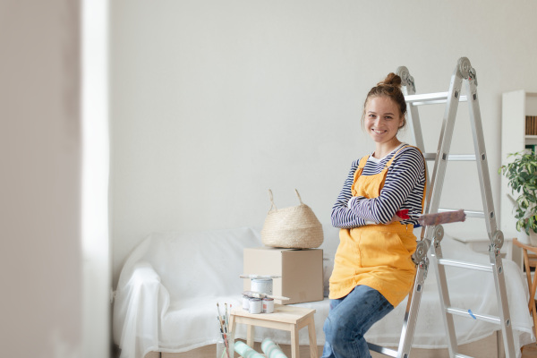 Happy young woman having break during renovation her house.