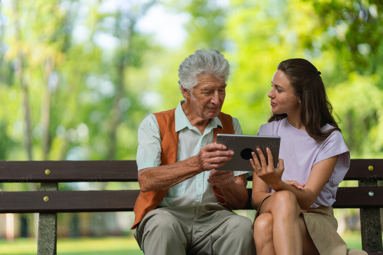 Caregiver helping senior man to shop online on a tablet, The risk of online shopping scams targeting older people.