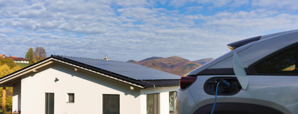 Charging electric car with own charger in house, sustainable transportation concept.