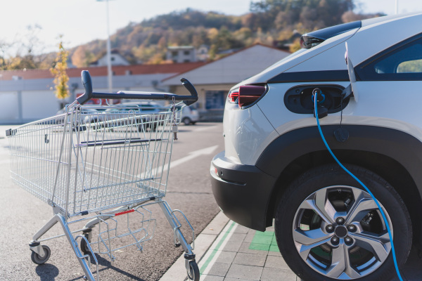 Modern electric car charging at a supermarket parking.