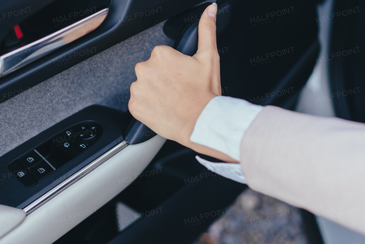 Close-up of young woman's hand closing a car doors.