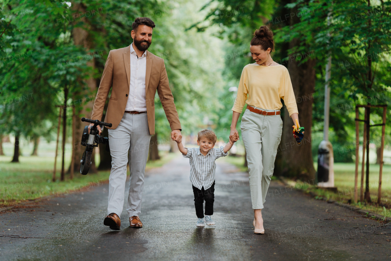 Young family with little son on a walk after work.