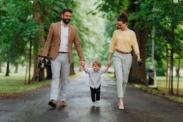 Young family with little son on a walk after work.