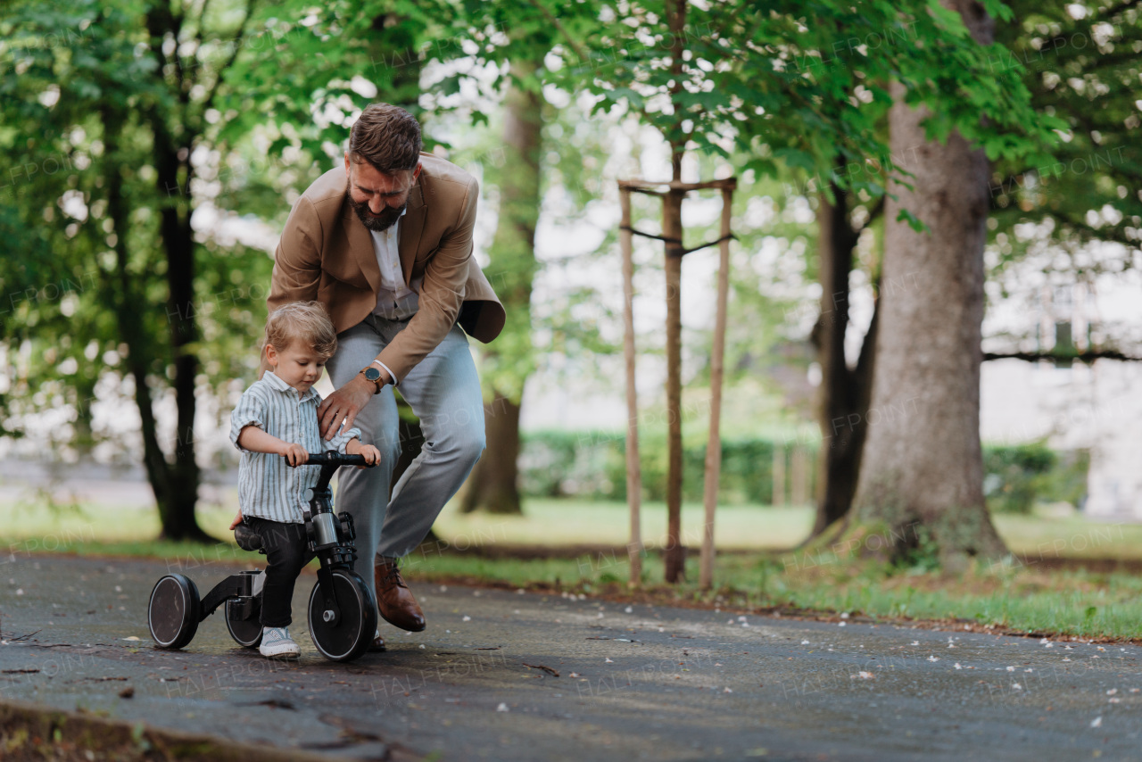 Single father with his little son spending together time in a public park. Working parent spending time with son after work day.