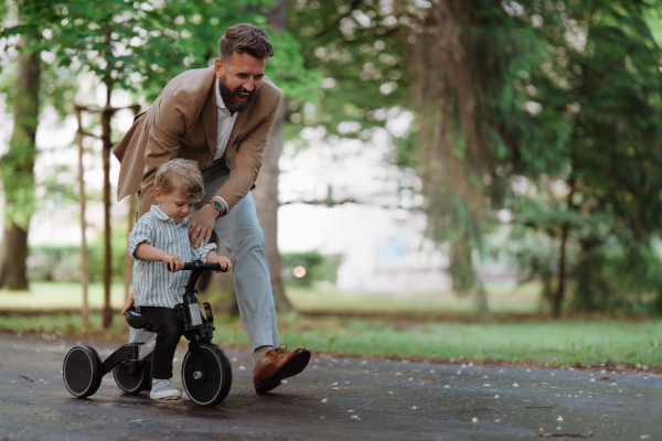 Single father with his little son spending together time in a public park. Working parent spending time with son after work day.