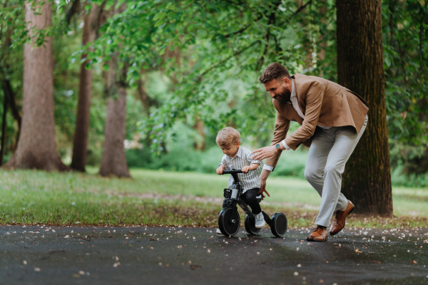 Single father with his little son spending together time in a public park.