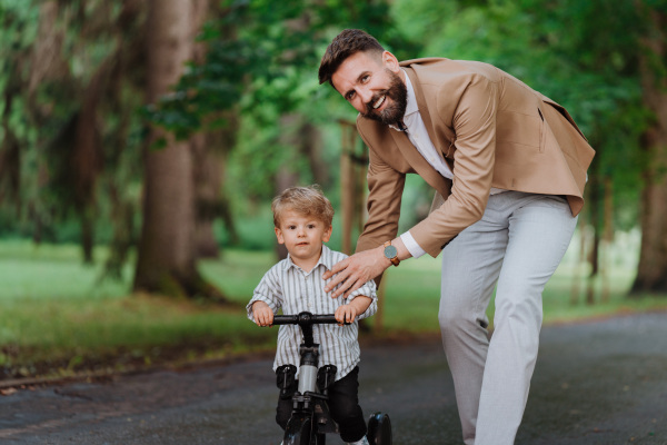 Single father with his little son spending together time in a public park.