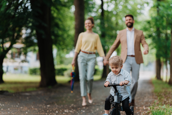 Young family with little son on a walk after work.