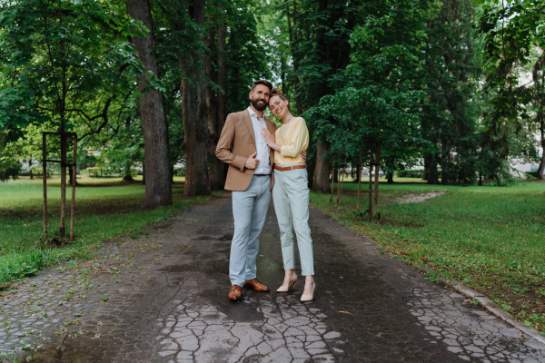 Young married couple on a walk in city park after work. Working couple spending time outdoors after long work day. Work-life balance concept,