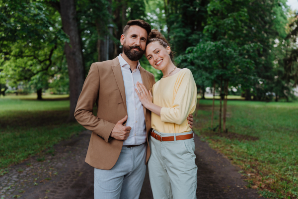 Young married couple on a walk in city park after work. Working couple spending time outdoors after long work day. Work-life balance concept,