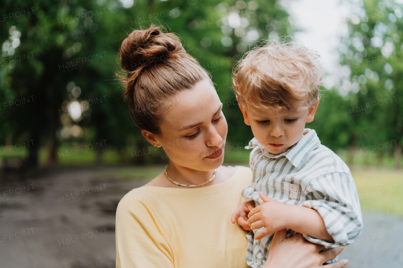 Young mother with little son on a walk after work. Working mother picking up her son from daycare.