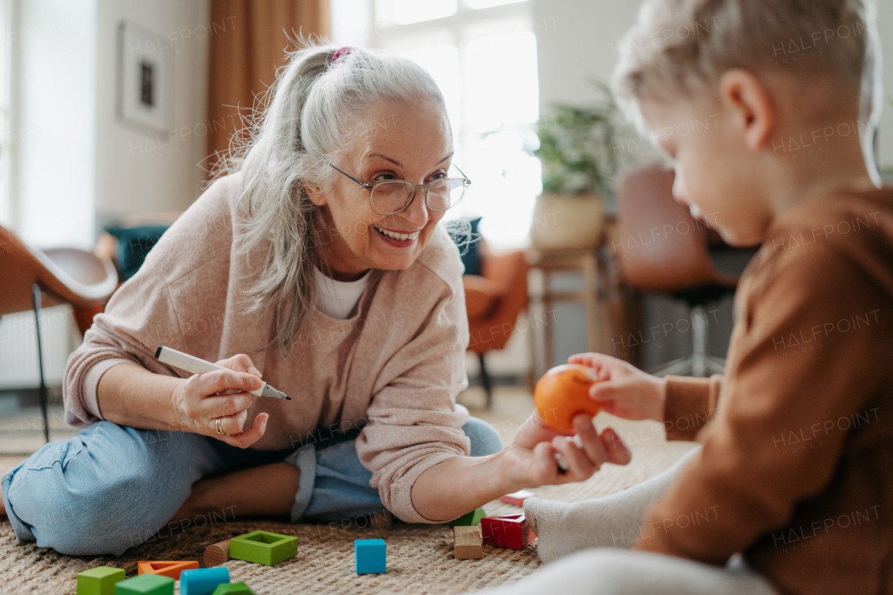 Grandmother playing with her little grandson, having fun.