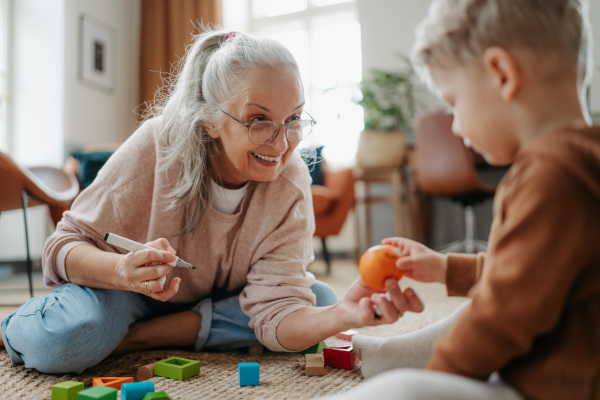 Grandmother playing with her little grandson, having fun.