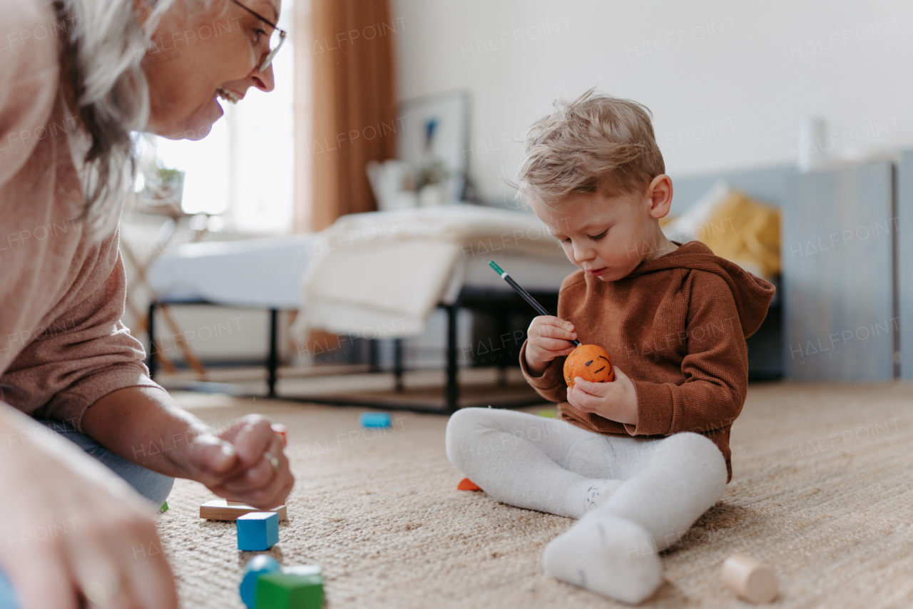 Grandmother playing with her little grandson, having fun.