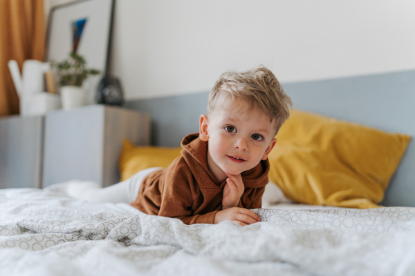 Portrait of little boy lying in the bed.