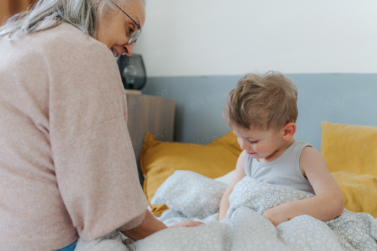 Grandmother giving her grandson in a bed.