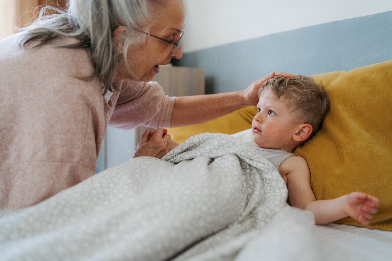 Grandmother giving her grandson in a bed.