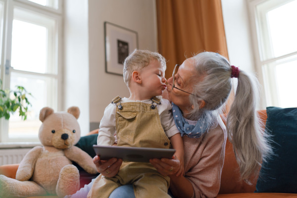 Grandmother giving a kiss to her grandson. Grandson giving kiss to his grandmother.