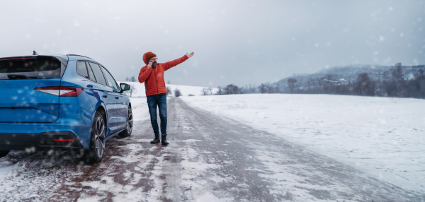 Angry man standing by electric car, battery run out of power before reaching destination. Man phone calling for help waiting for, breakdown service car, tow truck, Banner with copy space.