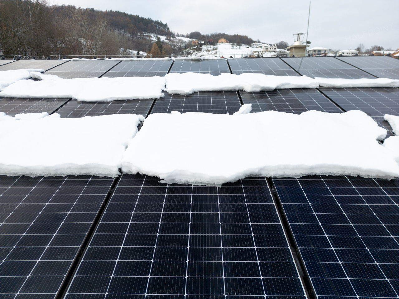 Roof solar panels with snow on top of them. Solar energy in the winter.