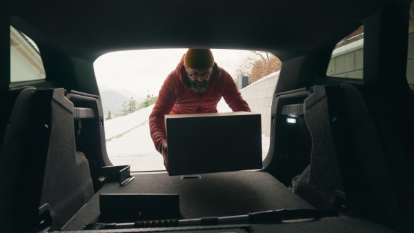 Man buying christmas gifts during winter, bringing box home. Mature man moving to the new house, packing into cardboard boxes.