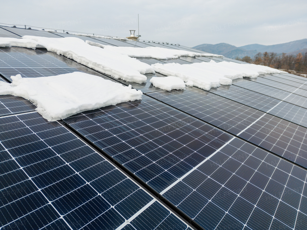 Roof solar panels with snow on top of them. Solar energy in the winter.