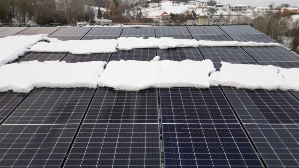 Roof solar panels with snow on top of them. Solar energy in the winter.