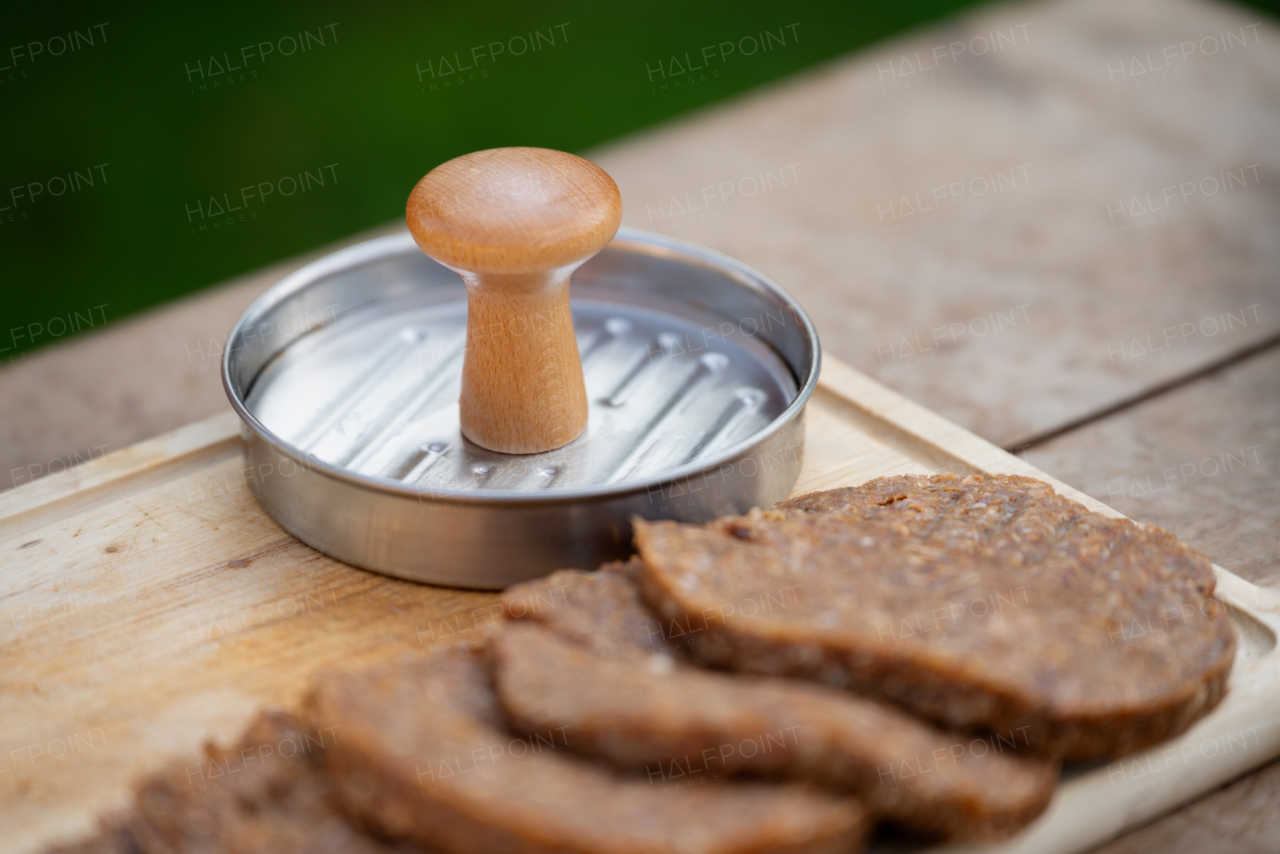 Close up of preparing meat for hamburgers. Using burger patty press to shape groud meat