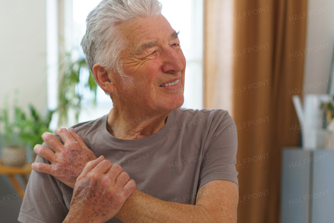 Portrait of senior man with pain in his arm.