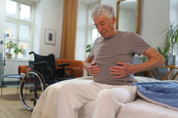 Portrait of senior man with pain in his stomach.