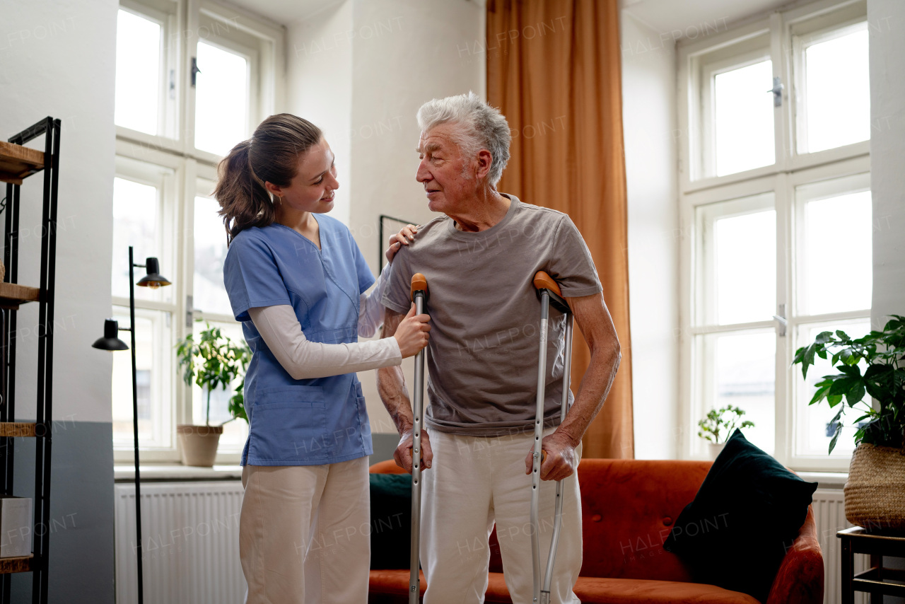 Young nurse helping a senior man with walking.