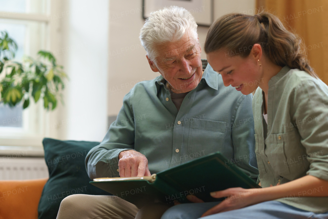 Senior man with his grandaughter reading book.