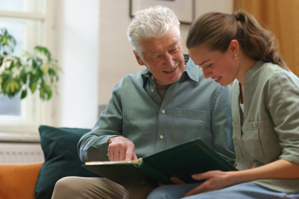 Senior man with his grandaughter reading book.