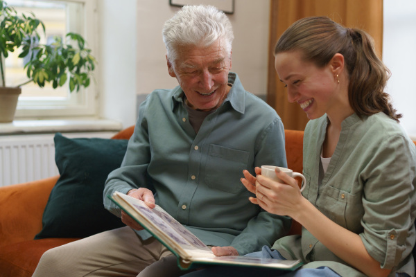 Senior man with his grandaughter reading book.