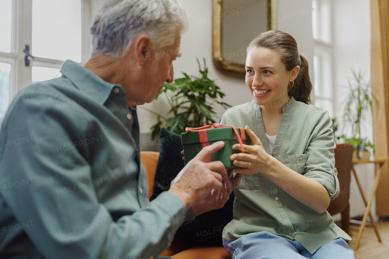 Senior man giving gift to his caregiver.