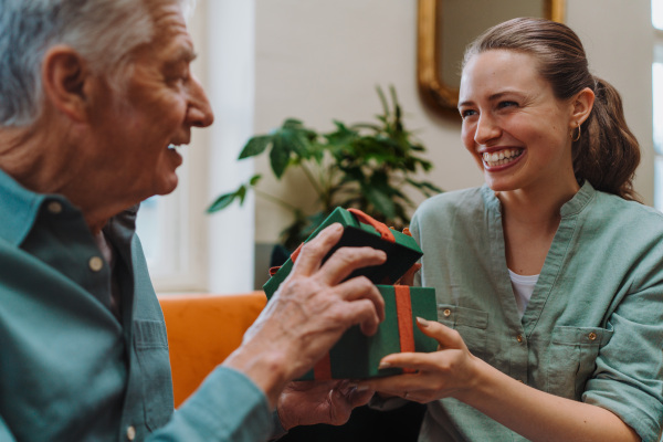 Senior man giving gift to his caregiver.