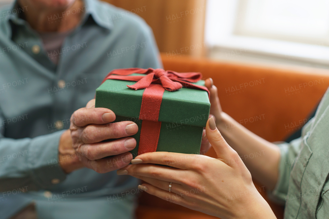 Senior man giving gift to his caregiver.