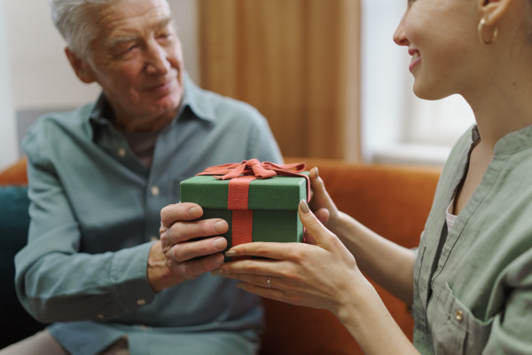 Senior man giving gift to his caregiver.