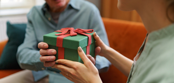 Senior man giving gift to his caregiver.