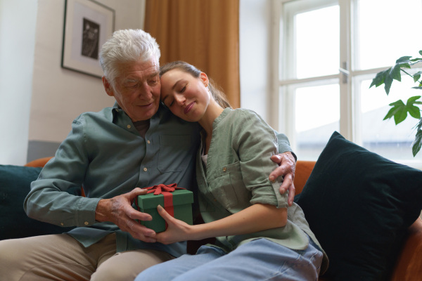 Senior man giving gift to his caregiver.