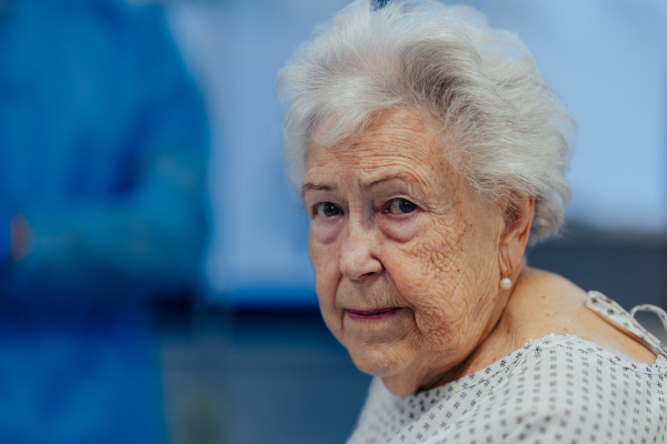 Portrait of scared senior patient on examination table in the hospital. Concept of the fear and anxiety about health problems in elderly people.