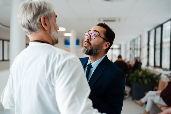 Violence against health workers. Patient is aggressive, have conflict with doctor in the hospital corridor. Visitor holding doctor by coat, screaming, threatening him.