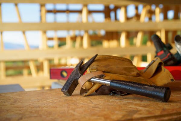 Close up of a construction tools inside of unfinished wooden house.