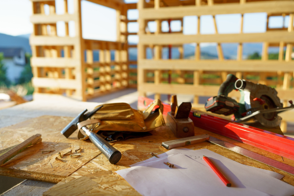 Close up of a construction tools inside of unfinished wooden house.