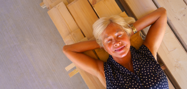 Top view of happy senior woman lying at a wooden board, wide photography. Copy space.